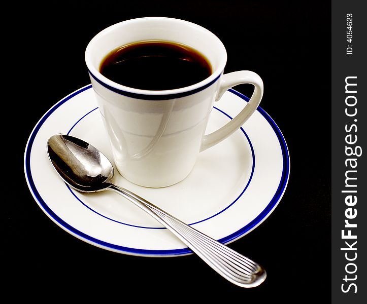 Cup of black coffee, saucer and spool isolated on black background. Cup of black coffee, saucer and spool isolated on black background.