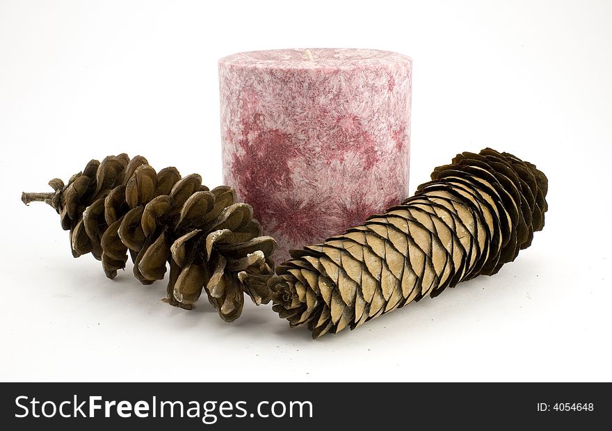 Pink candle and pine cones isolated on white backfround. Pink candle and pine cones isolated on white backfround.