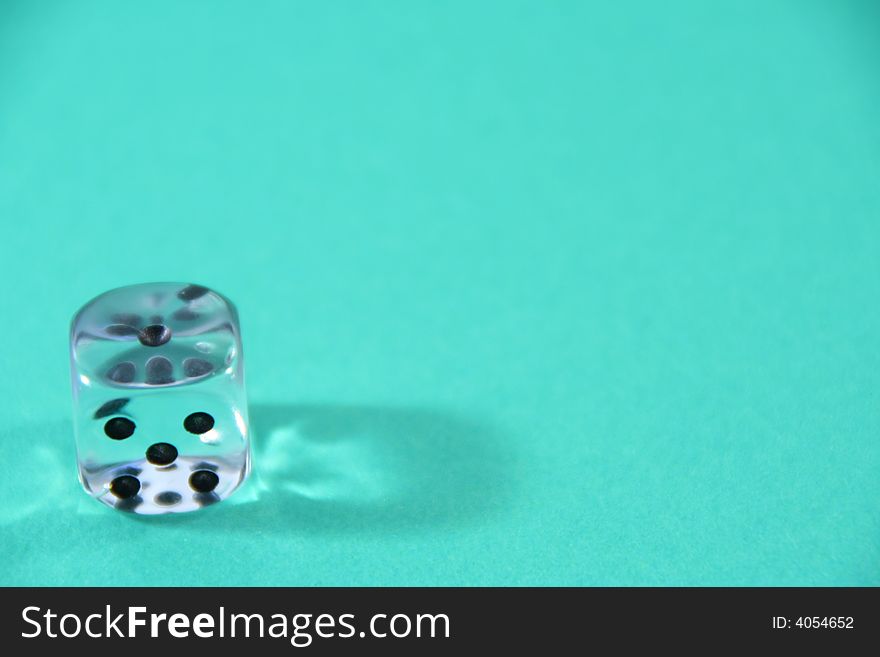 A dice on a green table