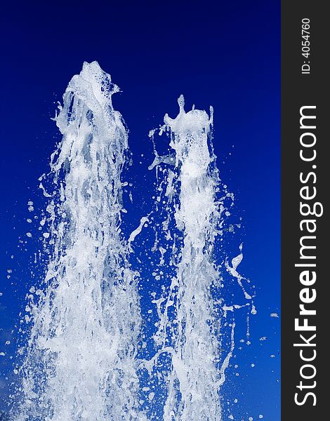 Fountain of water on a background of the blue sky. Fountain of water on a background of the blue sky