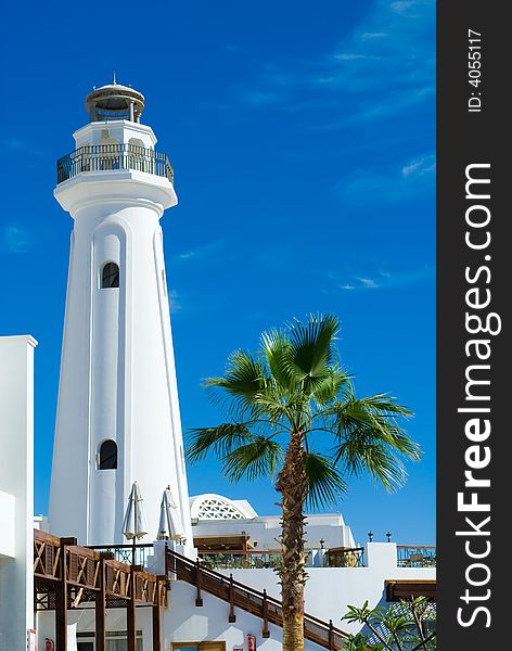 Lighthouse and palmtree with a beautiful blue sky