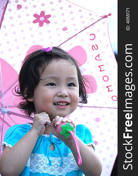 Cute beautiful Chinese young child under umbrella in summer