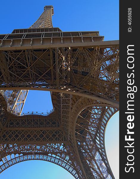 The Eiffel Tower viewed from an unusual angle. Perfect blue sky above. The Eiffel Tower viewed from an unusual angle. Perfect blue sky above.