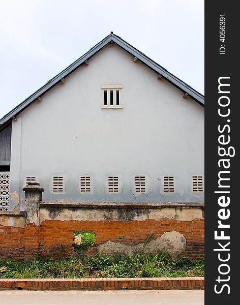 Rundown house with red brick fence