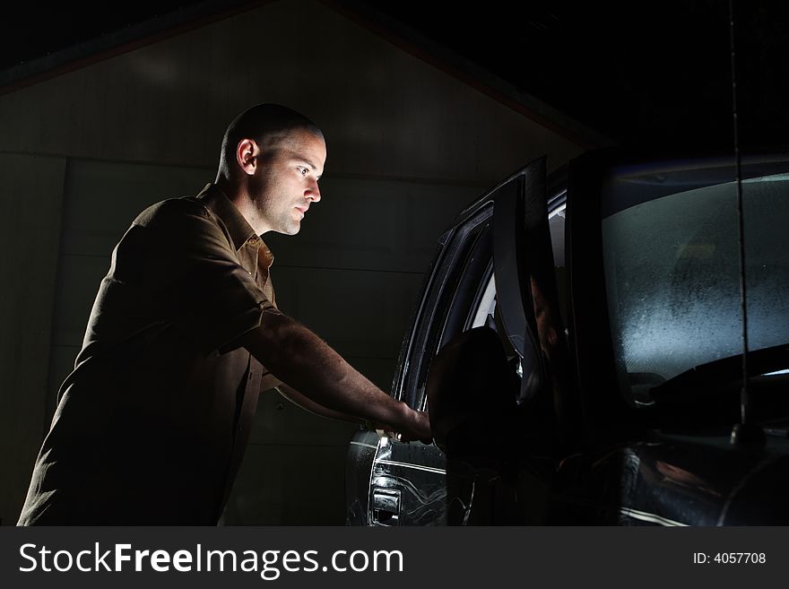 Night shot of a man looking inside a vehicle and seeing a bright light. It's unexplainable. Night shot of a man looking inside a vehicle and seeing a bright light. It's unexplainable.