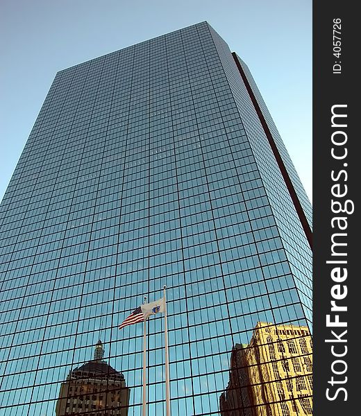 Reflection on John Hancock building with flag