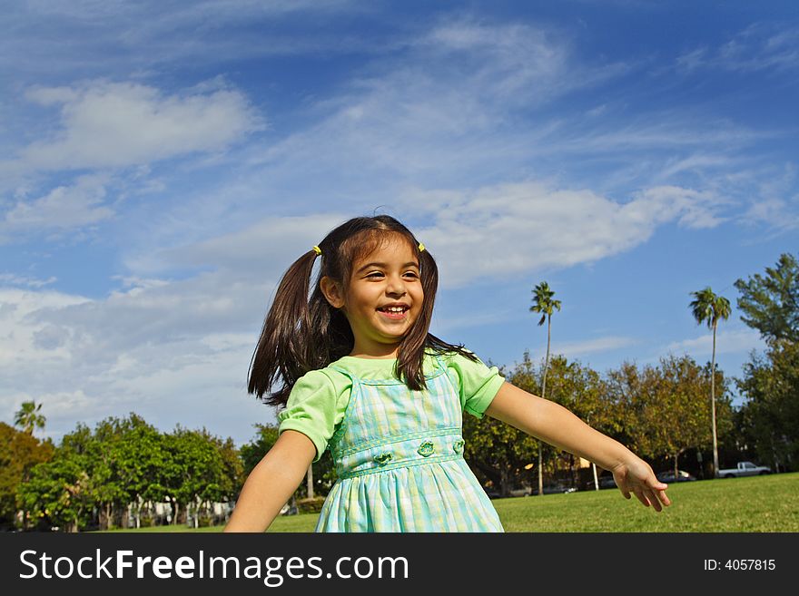 Girl in a park pretending to fly