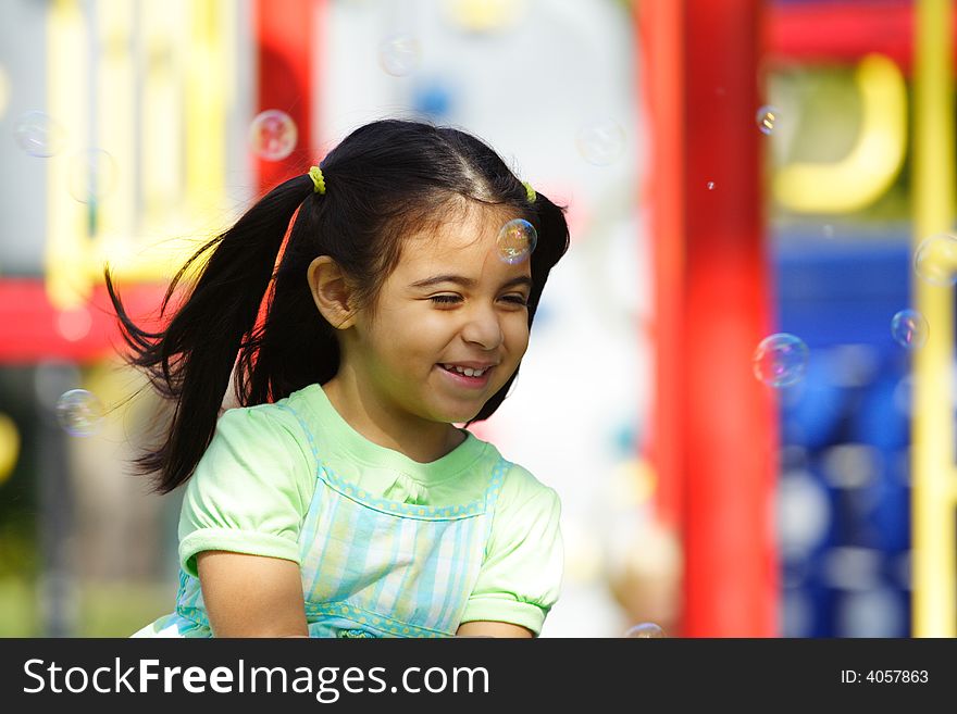 Little Girl blowing bubbles at the playground