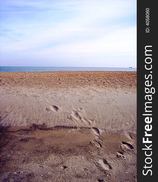 Footprints in the sand with ocean and sky in background. Footprints in the sand with ocean and sky in background