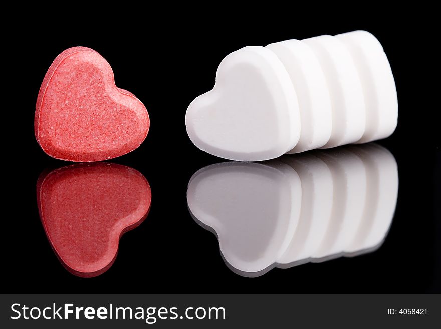 Red and white candy hearts on black background