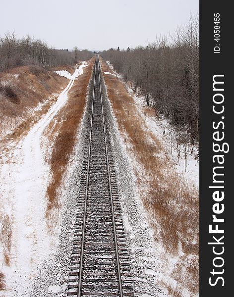 Single snow covered railroad track stretching into the distance. Single snow covered railroad track stretching into the distance