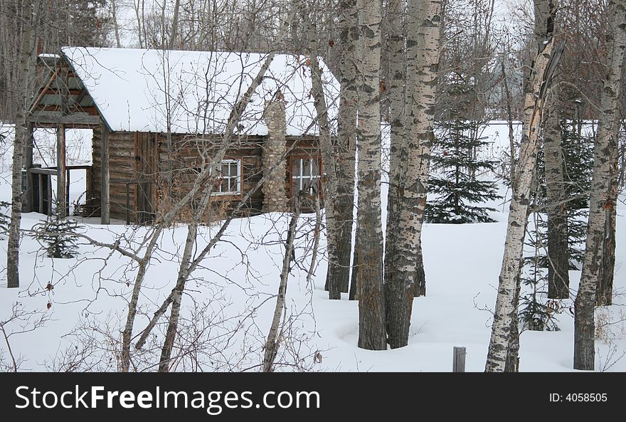 A cozy and romantic log cabin hidden away in the winter forest. A cozy and romantic log cabin hidden away in the winter forest
