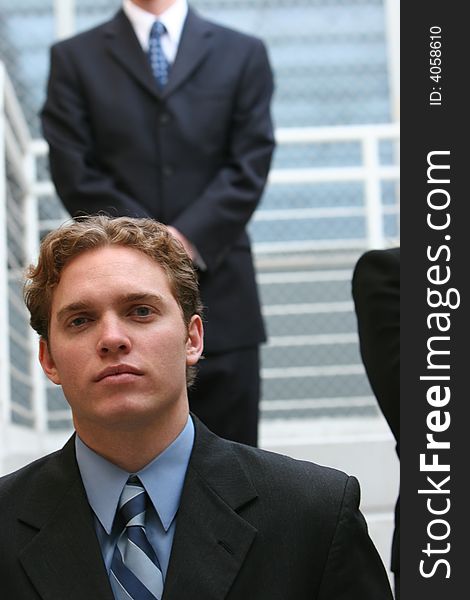 Three business people all looking forward standing on steps. Three business people all looking forward standing on steps