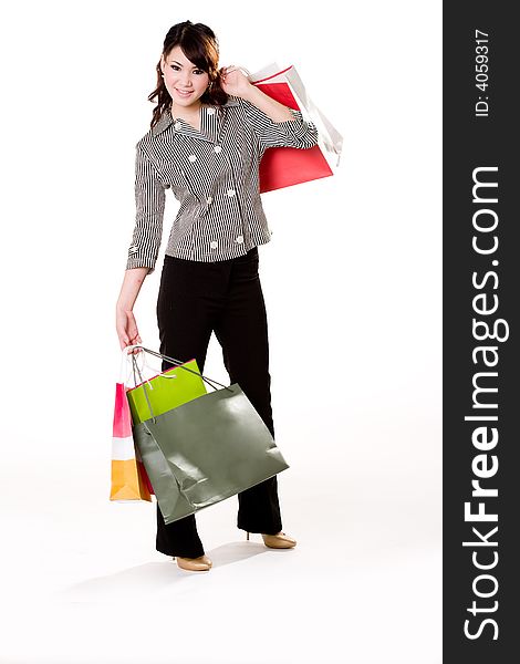 Young woman happily shopping full of paper bags. Young woman happily shopping full of paper bags