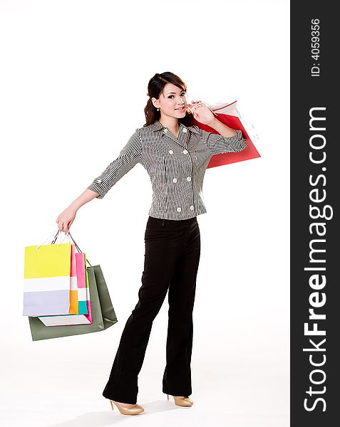 Young woman happily shopping full of paper bags. Young woman happily shopping full of paper bags