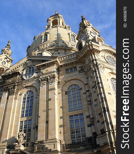 The Church of Our Lady in Dresden from below in front of an lightly cloudy blue sky.