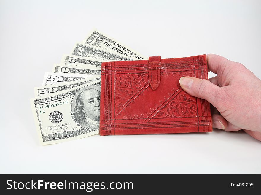 U.S. currency in a red wallet held in a hand. U.S. currency in a red wallet held in a hand.