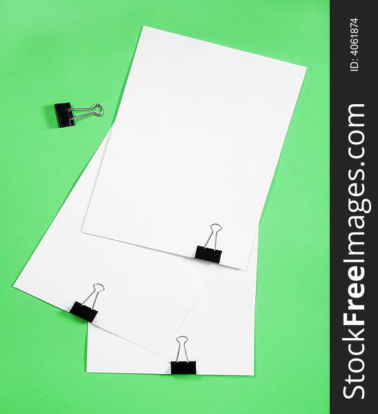 Isolated white paper with  clamp on green background