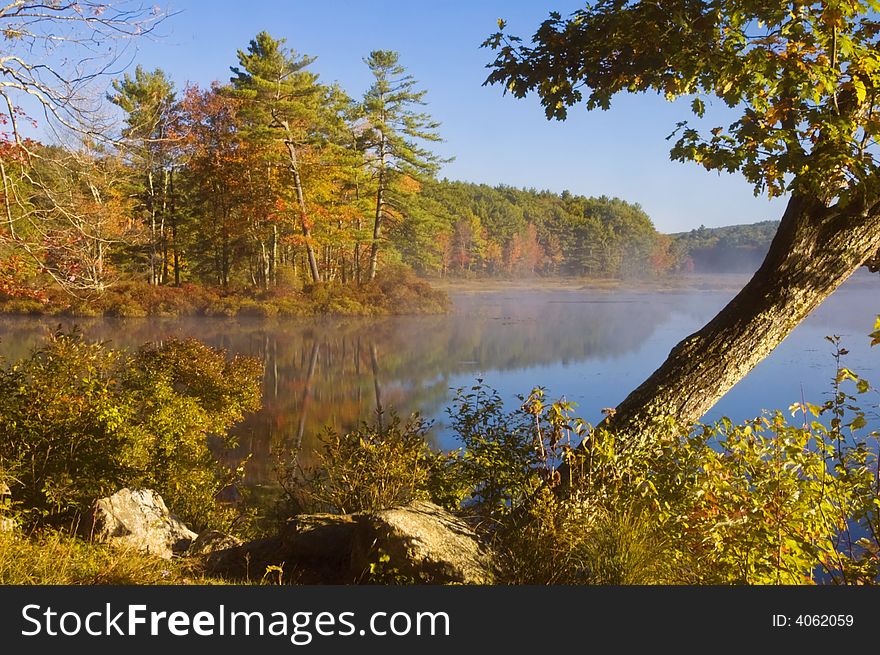 Morning sunlight reveals, bright autumn colors and mist rising off of Harvard Pond in Petersham, MA. Morning sunlight reveals, bright autumn colors and mist rising off of Harvard Pond in Petersham, MA.