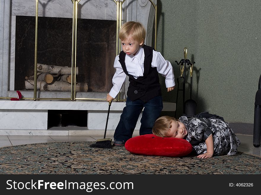 Little miss and steward. Portrait of two cute children in front of fireplace