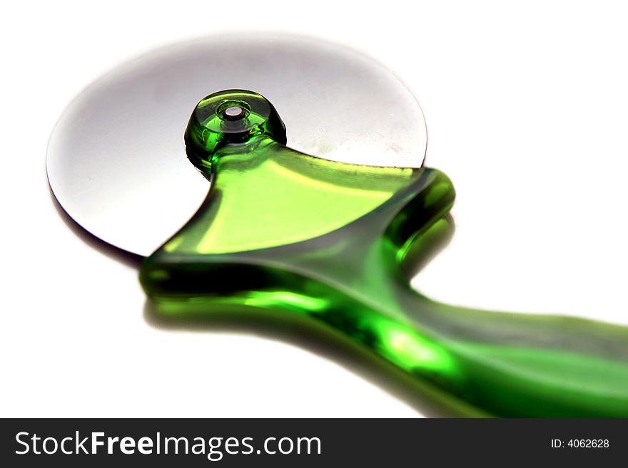 Green pizza cutter on a light background