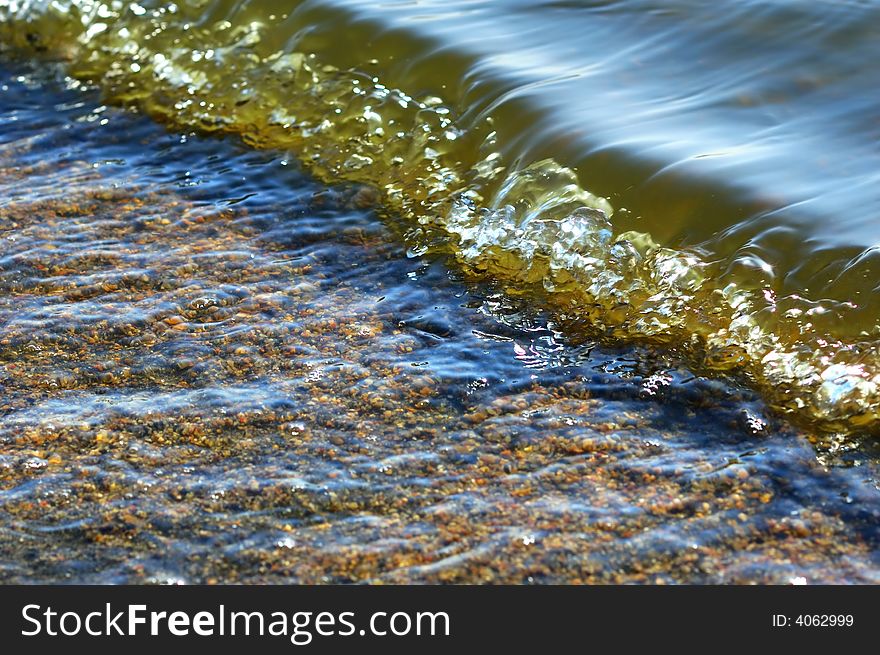 Detail of a little wave rolling into the beach