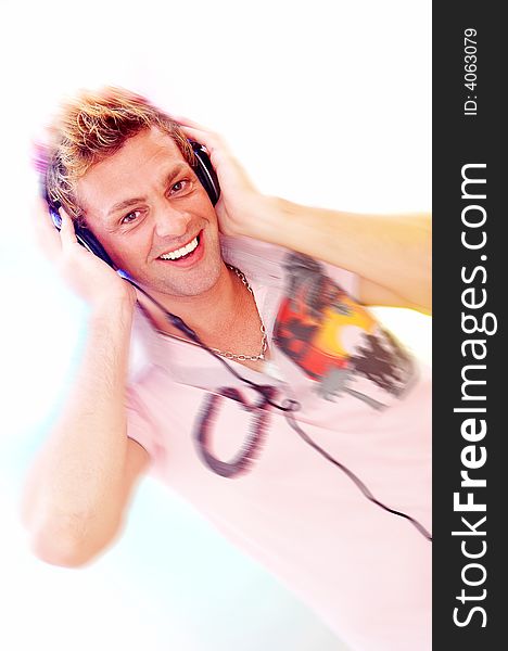 Motion blurred  portrait of young  male listening music via earphones. Focused on face. Motion blurred  portrait of young  male listening music via earphones. Focused on face.