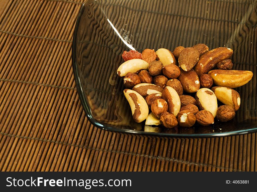 A mix of nuts in a glass dish