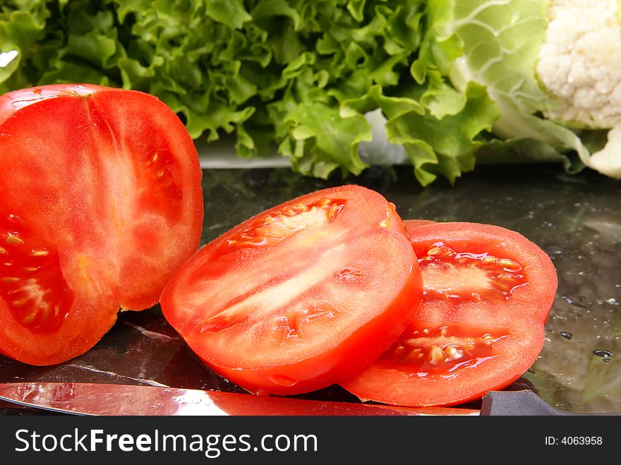 Fresh sliced ripe tomatoes on black marble cutting board. Fresh sliced ripe tomatoes on black marble cutting board.