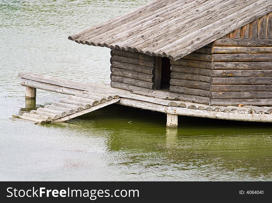 A wooden birdhouse built as shelter for geese on a lake. A wooden birdhouse built as shelter for geese on a lake.