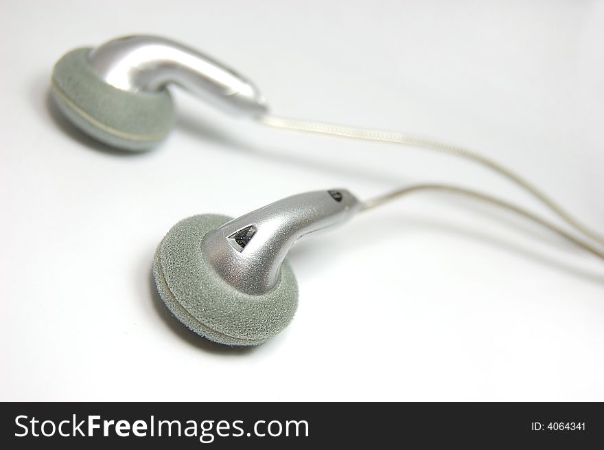 Small metallic headphones on slightly gray background