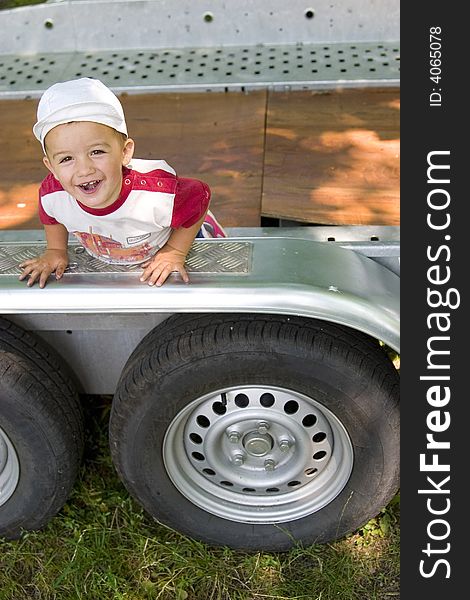 A kid playing on a huge vehicle, happy. A kid playing on a huge vehicle, happy