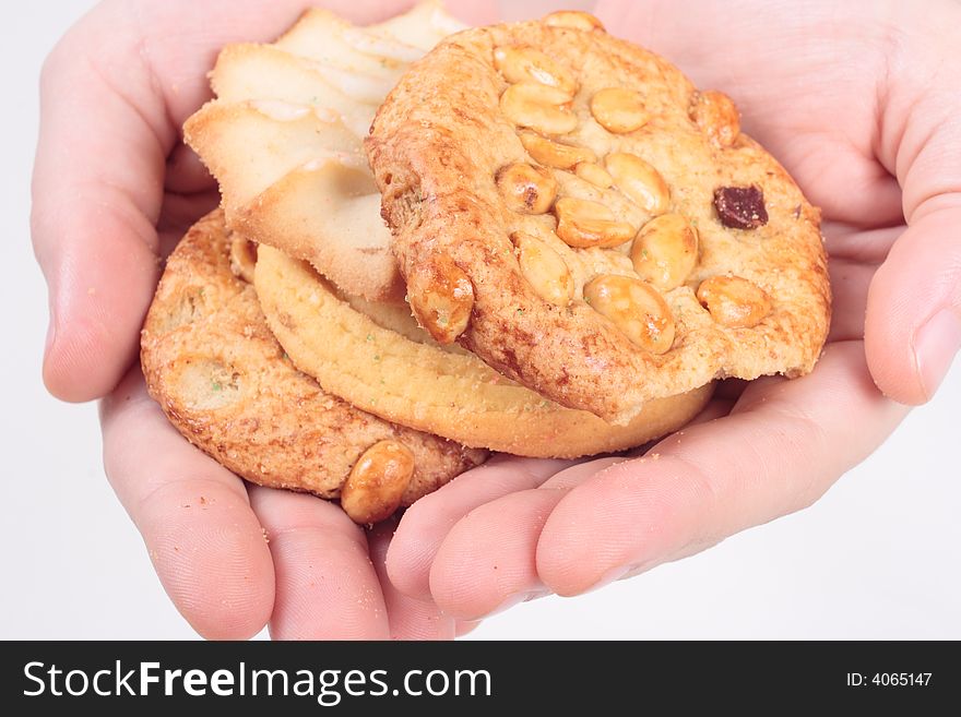 Hands offering assorted cookies on isolated white background close up. Hands offering assorted cookies on isolated white background close up.