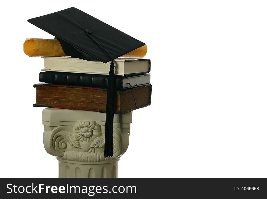 Mortar board and diploma on stack of books
