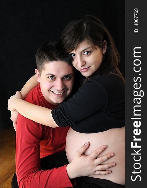 A view with a pregnant woman and her husband. Happy family. A view with a pregnant woman and her husband. Happy family