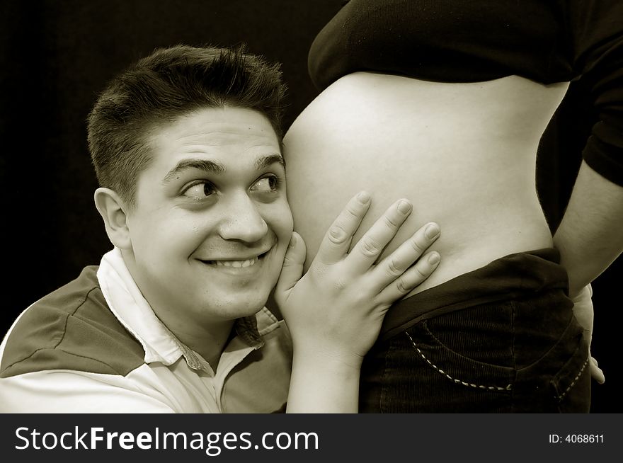 A view with a pregnant woman and her husband. Happy family. A view with a pregnant woman and her husband. Happy family