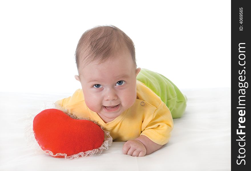 Baby with a soft toy in the form of heart over white