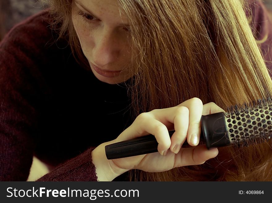 Girl combing her hair with brush