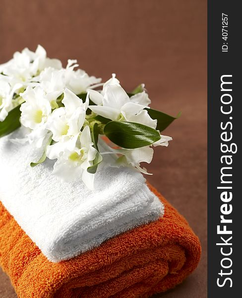 White and orange towels and orchid. White and orange towels and orchid