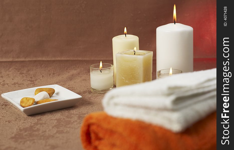 Candles and towels on brown background. Candles and towels on brown background