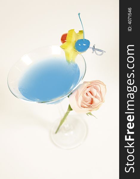 Blue classic cocktail with rose decoration and starfruit. Blue classic cocktail with rose decoration and starfruit