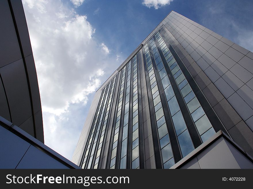 Big office building with blue sky and white clouds