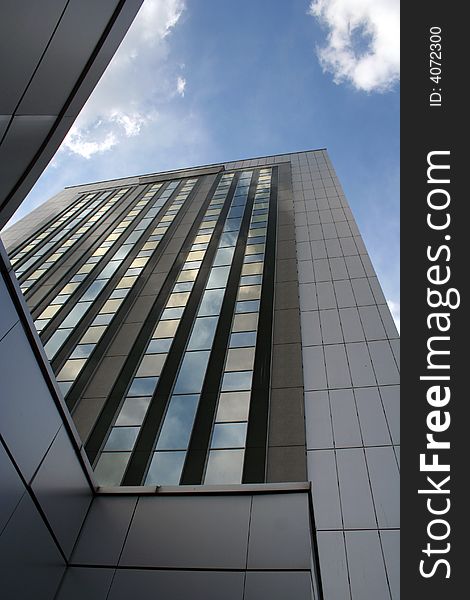 Big office building with blue sky and white clouds