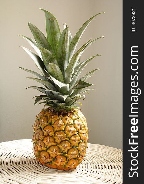 Large full pineapple on a white table. Large full pineapple on a white table