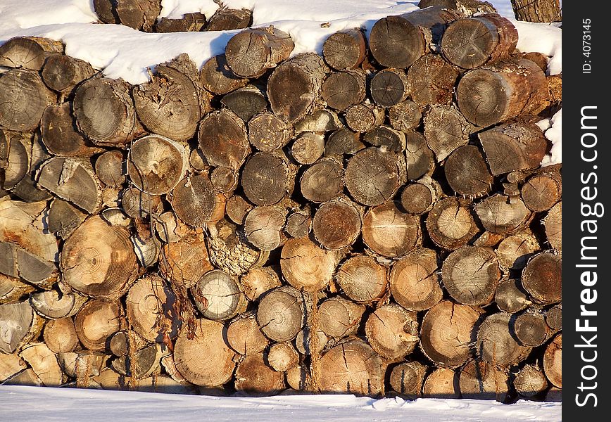 Wood logs with snow settled a top. Wood logs with snow settled a top.