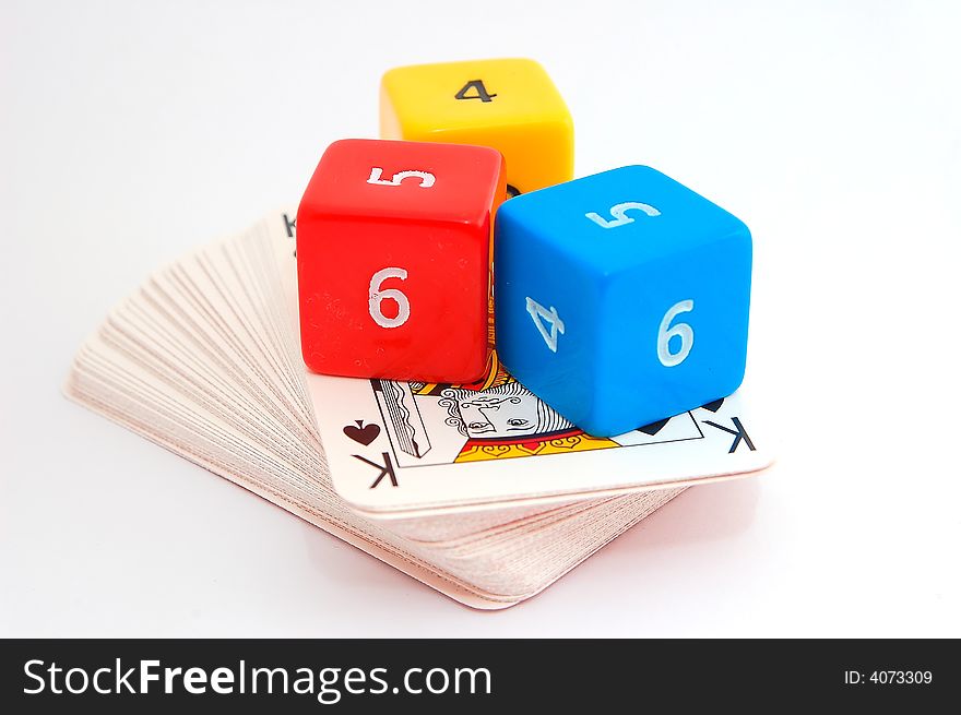 Three colorful dice on deck of cards with king of spades