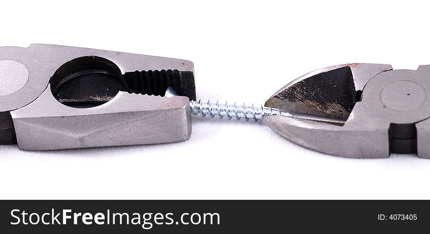 Pliers and a cutter holding a screw on white background. Pliers and a cutter holding a screw on white background