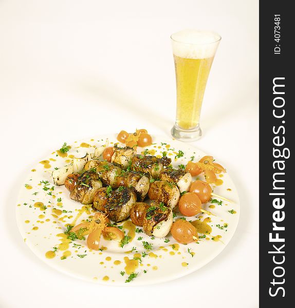 Meat skewers with mushrooms and onions and cherry tomato served with beer