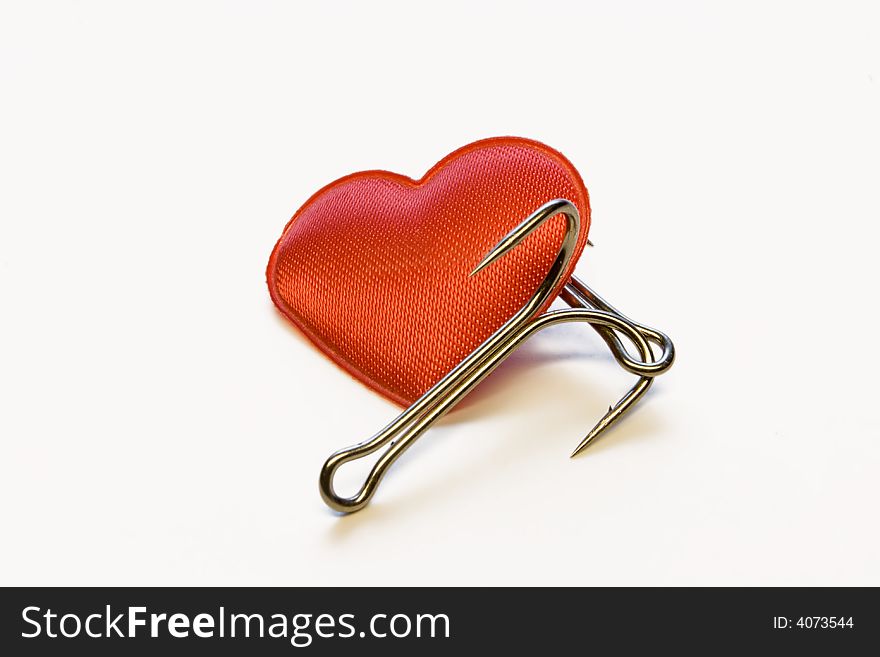 Red heart with a fishing hook on a white background