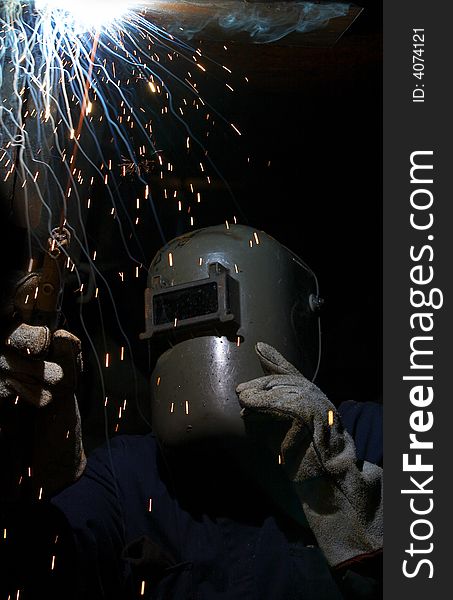 A welder working at shipyard at night. A welder working at shipyard at night